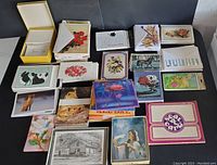 Top view of the lot laid out on a black surface showing multiple vintage unused greeting cards including dogs, flowers, animals, and invitation designs.