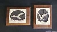Two limited edition marble relief plaques by Michael R. Bailot mounted on wood, showing details of birds in flight.