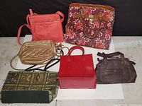 Lot overview showing all six handbags in various styles and colors against a black backdrop.