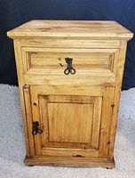 Front view of rustic wood side-end table showing drawer and cabinet door with wrought iron handles and nail hinges.