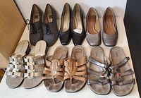 Top view of seven pairs of women's size 7 shoes and sandals arranged in two rows showing various styles and colors.