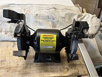 Front view showing both grinding wheels with safety guards and work lights