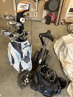 Overview showing Callaway bag with clubs, two-wheel cart, shoe bag and golf ball pouch.
