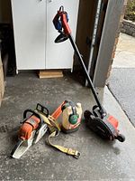 Black & Decker edger, Stihl chainsaw and oil container on garage floor