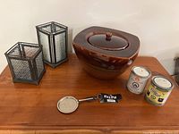 FirePot with lid, two metal candle holders, two unopened fuel pots, flame snuffer on wood table