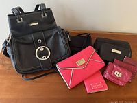 Overview of all six purses showing various styles and colors mostly black and pinks.