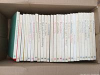 Top view of 27 Time Life Foods of the World cookbooks tightly packed in a box, showing titles.