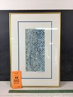 Full view of the framed artwork showing geometric circles and grid pattern with blue matting and gold frame.