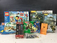 Photo of various unopened building sets including LEGO Pirate Dock and Treasure Island, Best-Lock Humvee sets, and Hasbro G.I. Joe with figures.