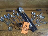 Top down photo of the full assortment of flatware pieces arranged on a wooden surface.