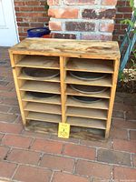 Front view of wooden box with pie tins inside and note card