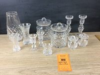 Full group shot of 12 Waterford crystal pieces showing all paired items and individual vases, arranged on wooden surface with black background