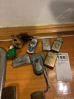 Photo showing seven lighters including novelty figures, Zippo style and flint lighter, laid out on a wooden surface