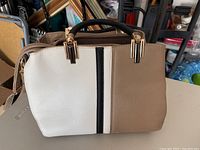 Front view of structured tri-color handbag showing color block design and gold-tone hardware