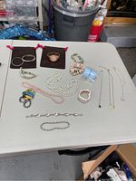 Table display of various bracelets, necklaces, mood ring and watch