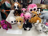 Front view of TY Beanie Boos and other stuffed animals group on floor showing a variety of animal characters including cat, dog, owl, flamingo, and others.