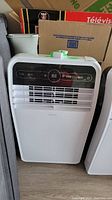 Front view of the white portable AC unit on floor