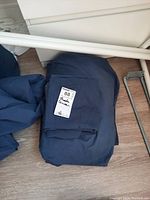 Photo showing folded blue queen size sheet set with pillow case labeled 'Queen 88'.