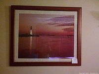 Framed lighthouse picture showing the entire artwork and frame, highlighting size and condition
