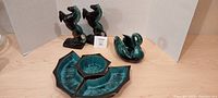 Photo of lot showing two rearing horses, one swan figurine, and a green glazed segmented serving dish with four compartments
