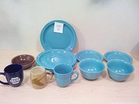 Photo of whole lot showing various blue ceramic dishes and assorted mugs including Tim Horton and Anapa mugs.