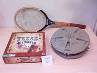 Photo showing all items: Texas Shake'em dice game box, wooden tennis racket, Star Wars Millennium Falcon ship model.