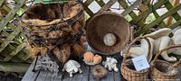 Photo shows assorted garden nic-nacs including baskets, bowls, animal figurines, and a bird nest.