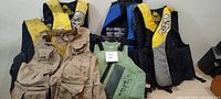 Group photo of five life jackets and one fishing vest showing condition and types.
