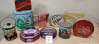 Overview of nine assorted old tins with diverse shapes and decorative patterns.