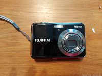 Front view of black FujiFilm FinePix AV250 digital camera showing lens, flash, and 16 megapixels label.