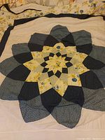 Close-up photo showing part of the quilted blanket with large starburst pattern and fabric detail