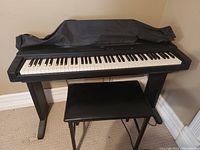 Full view of Yamaha electric piano on stand with bench and dust cover