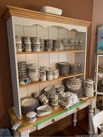 Overall view of hutch showing stacked plates, bowls, mugs and glasses