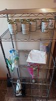 Full view of the four-tier metal wire shelving unit with some items on the shelves indicated for scale and condition assessment.