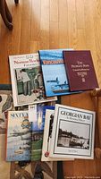 Photo showing assortment of eight books including 'Norman Rockwell Favorites', 'Vancouver', 'The People's Pope Toronto/Huronia', 'Sixty Years of Canadian Air Force', 'Georgian Bay Illustrated History', and others.
