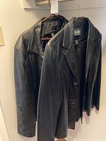 Two black leather jackets from Danier hung side by side showing their general appearance and collar style.