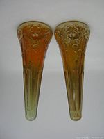 Top-down view of both vases, showing the amber to yellow gradient and embossed floral designs.