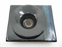 Top-down view of the square ceramic base with a circular bowl and metal flower frog insert at the center, showing dark glossy glaze and a bluish textured stripe.