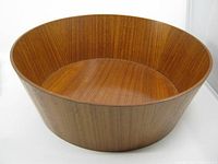 Full side view of the round teak wood bowl showing wood grain and bowl shape.