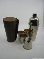 Full set of vintage mini martini shaker with four cups and leather case.
