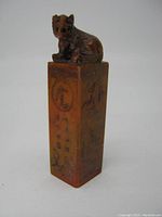 Full view of the stone chop showing seated tiger on top and carvings on the sides.