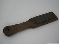 Top side view of the vintage sharpening stone showing the wooden handle and the diamond abrasive surface.