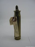 Front view of the 1938 trench art lighter showing the upright flint ignition and attached tag.