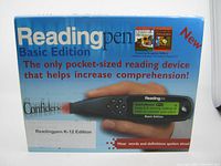 Front of box showing Readingpen Basic Edition K-12 pocket-size reading pen with tagline about increasing comprehension and feature images of children's dictionary and thesaurus.