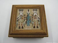 Top view of the wooden trinket box featuring Navajo sand painting under glass on the lid, showing two Native American figures and a central design.