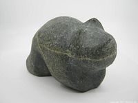 Front diagonal view of the stone bear sculpture showing overall form and texture.