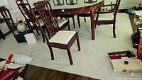 Wide view of the light beige area rug placed under a dining table with chairs, showing size and color.