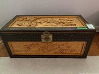 Front view of cedar chest showing relief carvings and metal latch