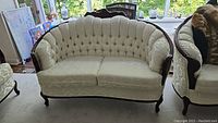Front view of loveseat showing scalloped tufted back and dual seat cushions