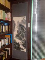 Full view of the hanging scroll mounted beside bookshelf and window.